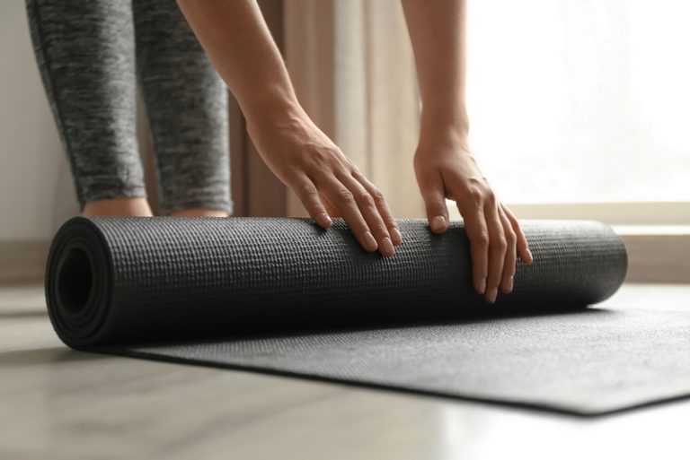 woman with yoga mat indoors
